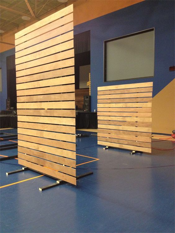 an empty room with blue flooring and wooden partitions