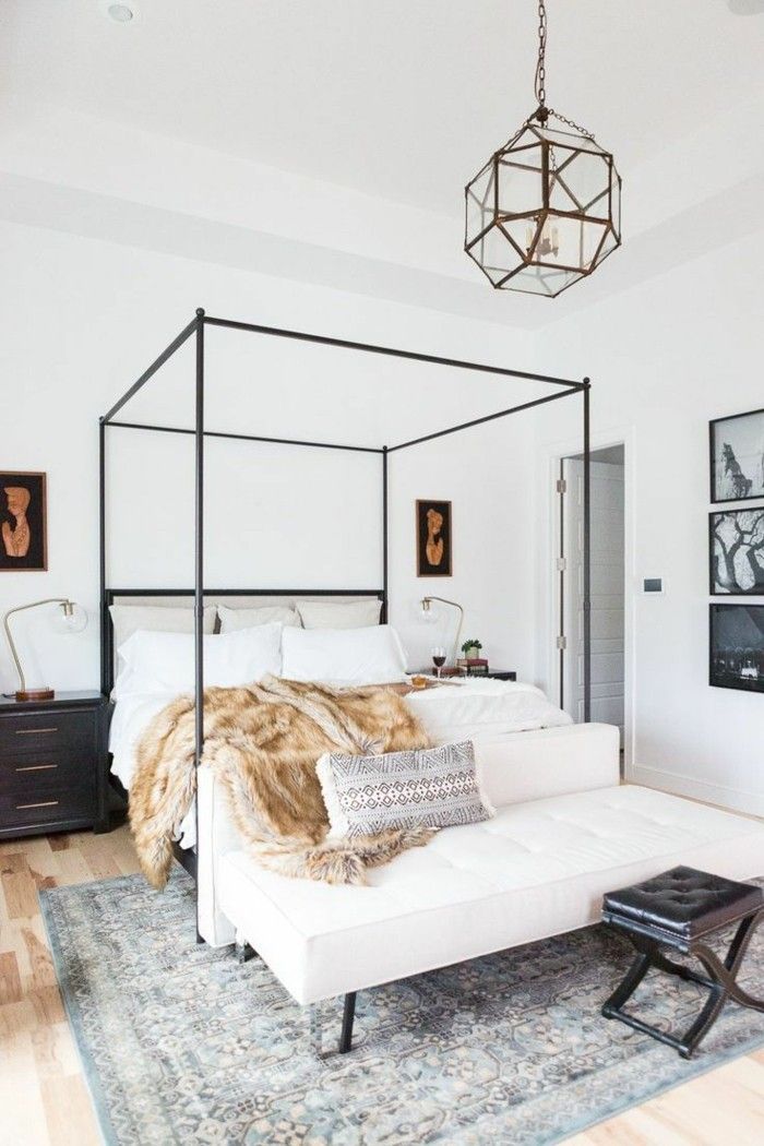 a white bed sitting on top of a wooden floor next to a black and white dresser