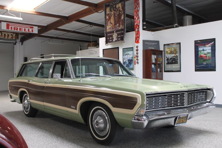 an old station wagon is parked in a garage next to other antique cars and memorabilia