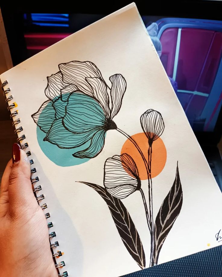 a person holding a notebook with flowers drawn on it