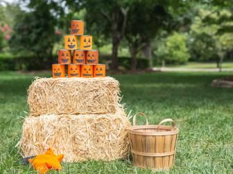 a hay bale with pumpkin faces on it