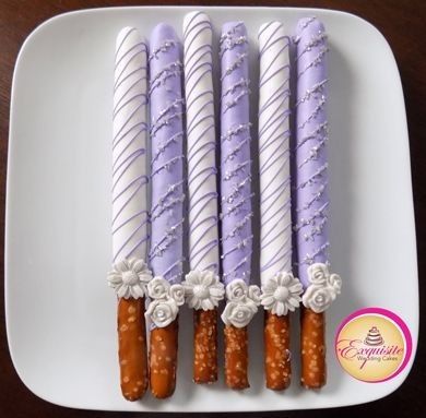 four candles are arranged on a plate with white and purple icing in the shape of flowers