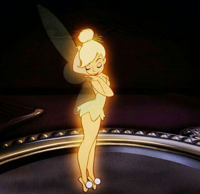 tinkerbell standing on top of a table in the dark