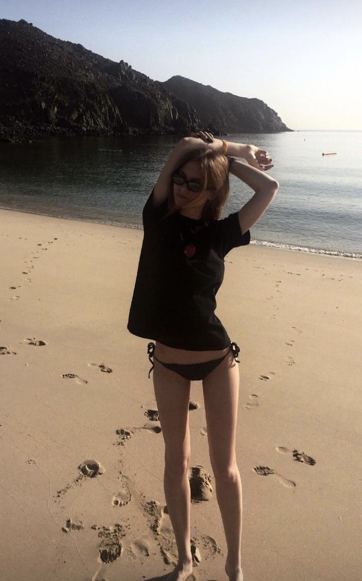 a woman standing on top of a sandy beach