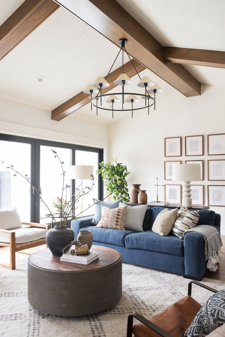 a living room with blue couches and pictures on the wall above them, along with a coffee table