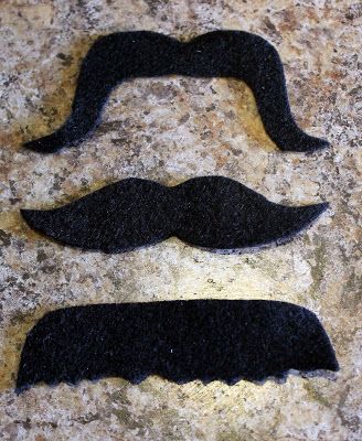 three black mustaches on a granite surface