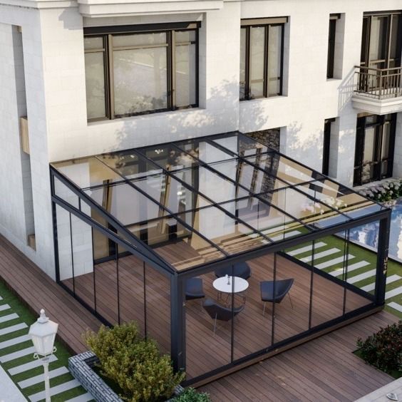 an aerial view of a house with a glass roof and patio area in the foreground