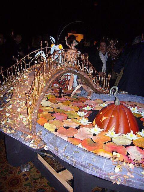 an elaborately decorated table with pumpkins and leaves on it at a halloween party