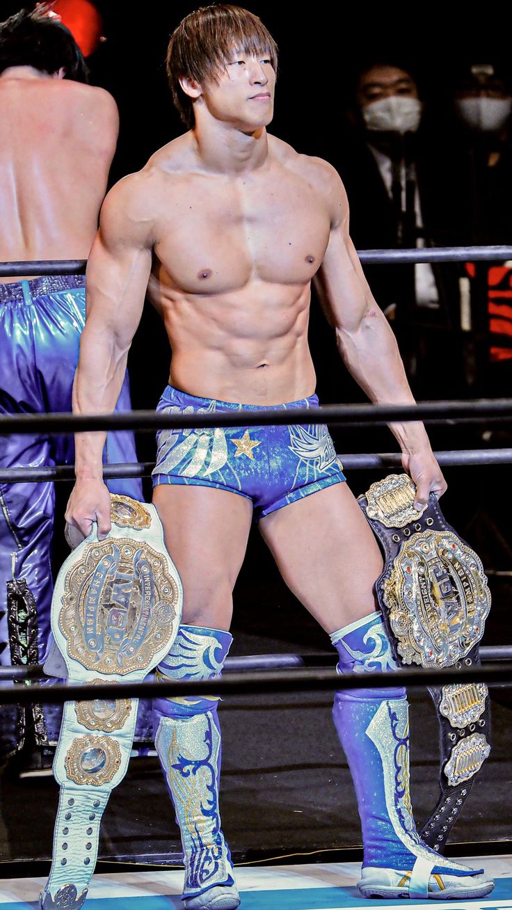 a shirtless man standing in the middle of a wrestling ring with his hands on his hips