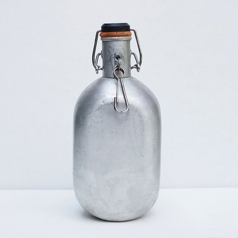 a metal flask with a cork top on a white background