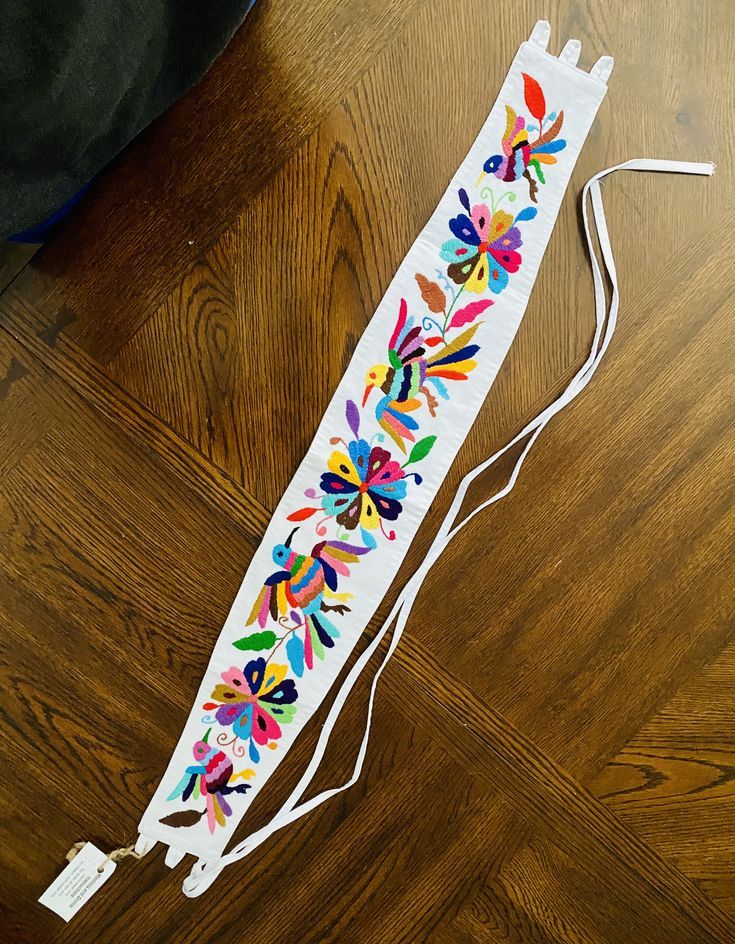 a white sticker with multicolored flowers on it sitting on top of a wooden floor