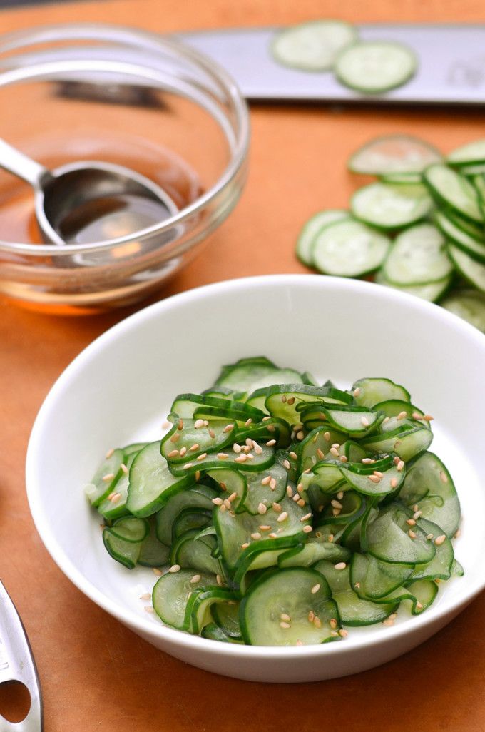 a white bowl filled with sliced cucumbers and seasoning