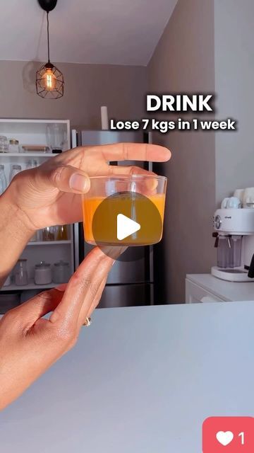 a person holding a glass in their hand with the text drink lose 7 kgs in 1 week