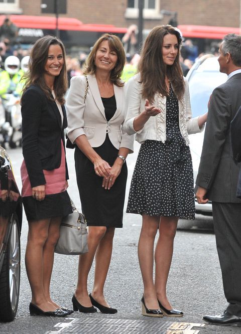 three women standing next to each other on the street