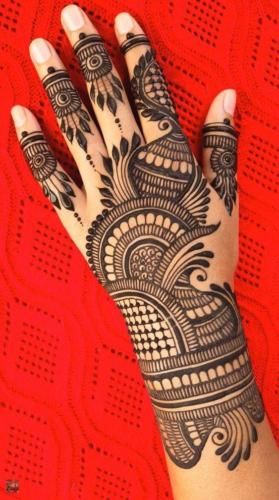 a woman's hand with henna tattoos on it