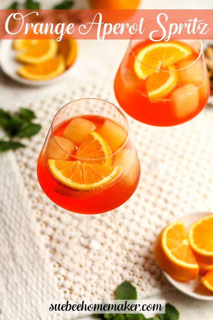 an orange apero spritz is garnished with sliced oranges