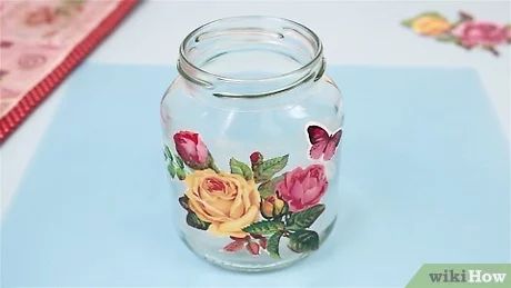 a glass jar with flowers painted on it