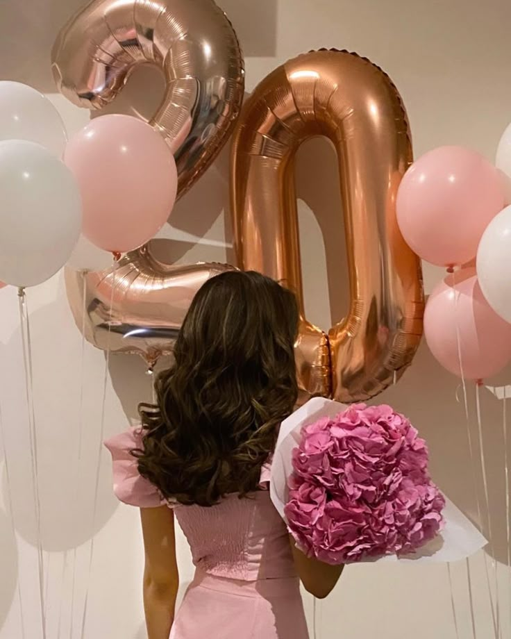 a woman standing in front of balloons and flowers