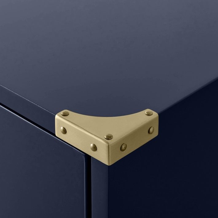 a close up view of the metal handles on a blue cabinet with gold rivets