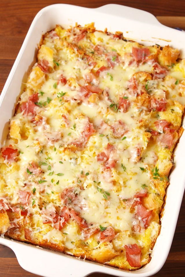 a casserole dish with ham, cheese and vegetables in it on a wooden table