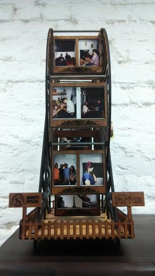 a wooden shelf with pictures on it in front of a white brick wall