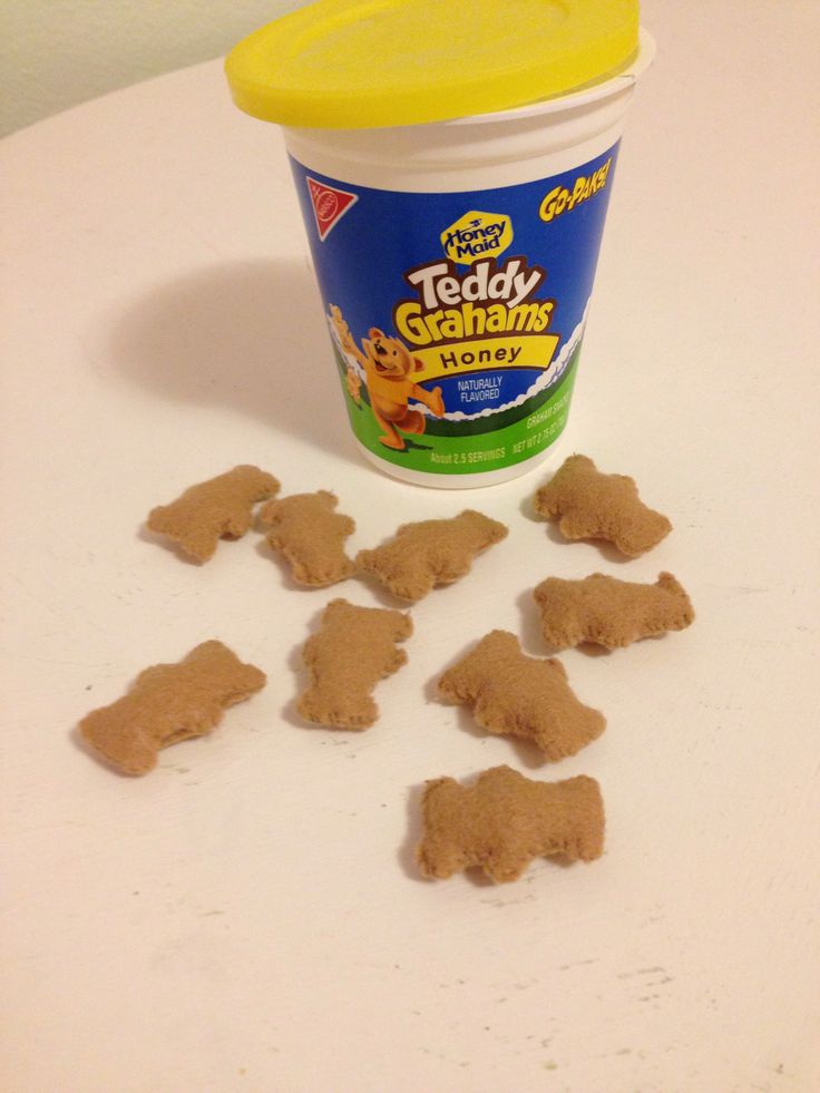 a cup of ice cream next to some dog treats on a white counter with a yellow lid