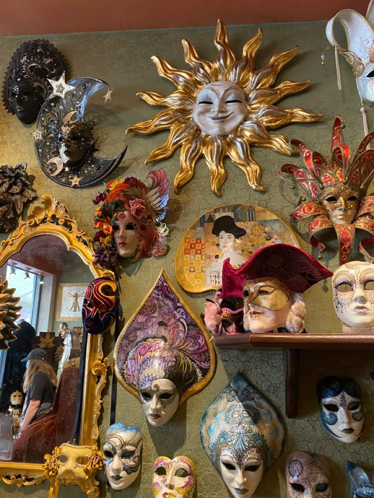 many masks are arranged on the wall in front of a mirror and other decorative items