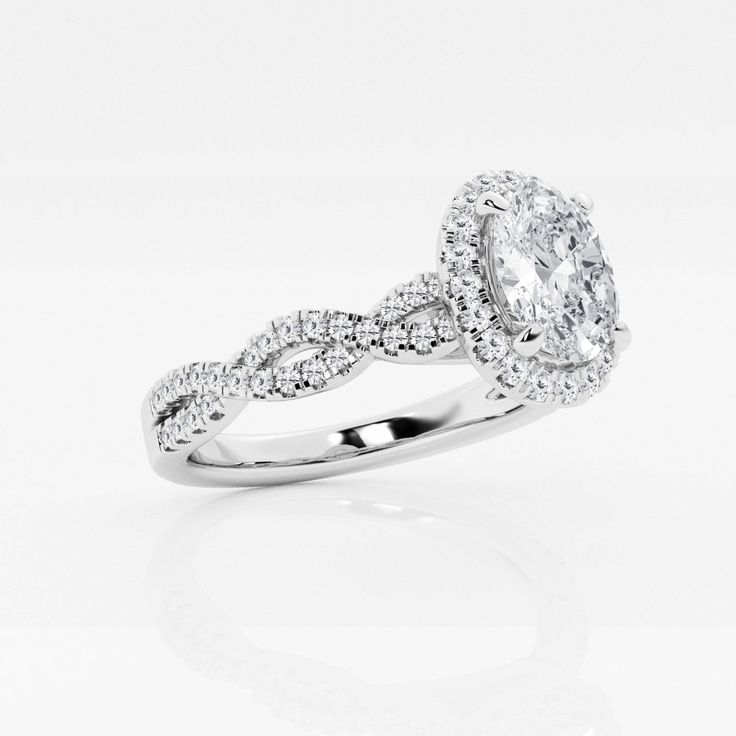 a white gold ring with an oval cut diamond in the center and twisted band around it