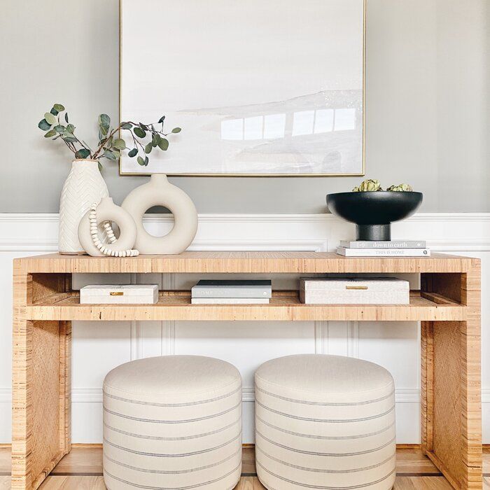 an instagram is displayed on the wall above a console table with two stools