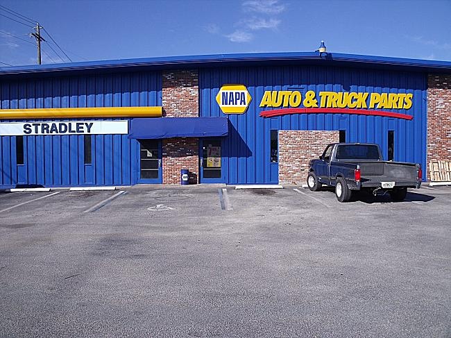 a truck parked in front of a auto and truck parts store