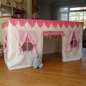 a pink and white play house with curtains