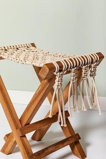 a wooden bench with rope and tassels on it