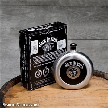 a jack daniels flask sitting on top of a wooden barrel next to a box