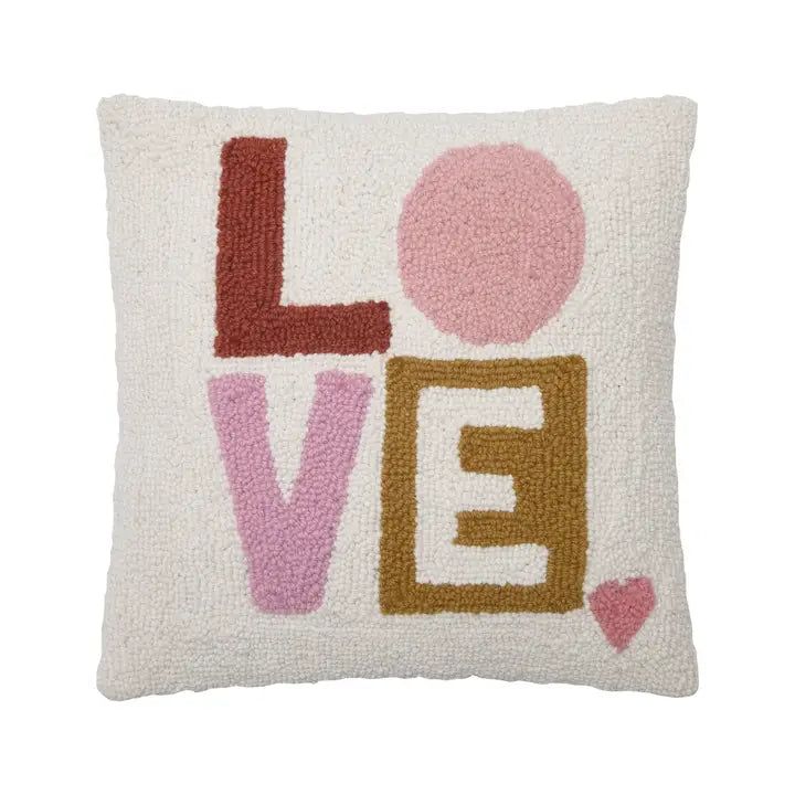 a pillow with the word love on it in pink, brown and white colors is shown