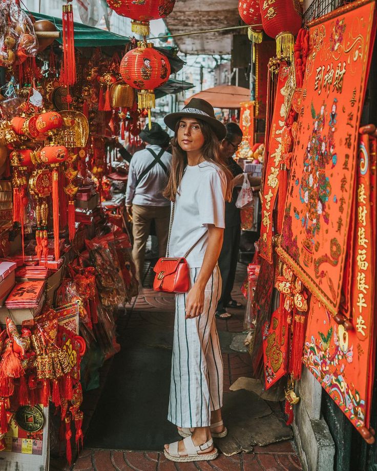 a woman standing in front of red lanterns