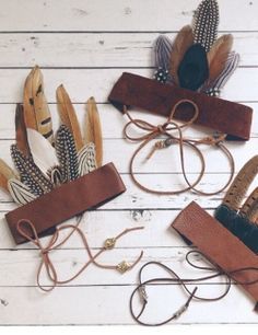 three leather headbands with feathers on them