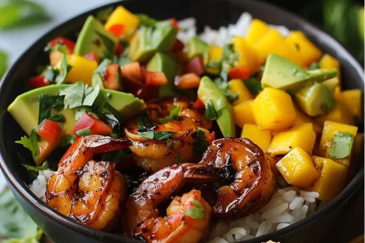 a bowl filled with shrimp, mango salsa and rice