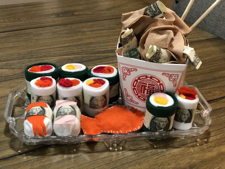 an assortment of sushi rolls and sauces in a container on a wooden table