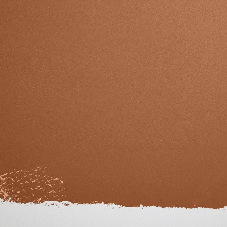 a brown wall with some white paint on it