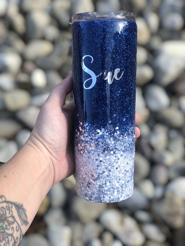 a person holding up a blue and white tumbler with the word save on it