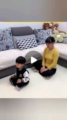 two children sitting on the floor in front of a couch