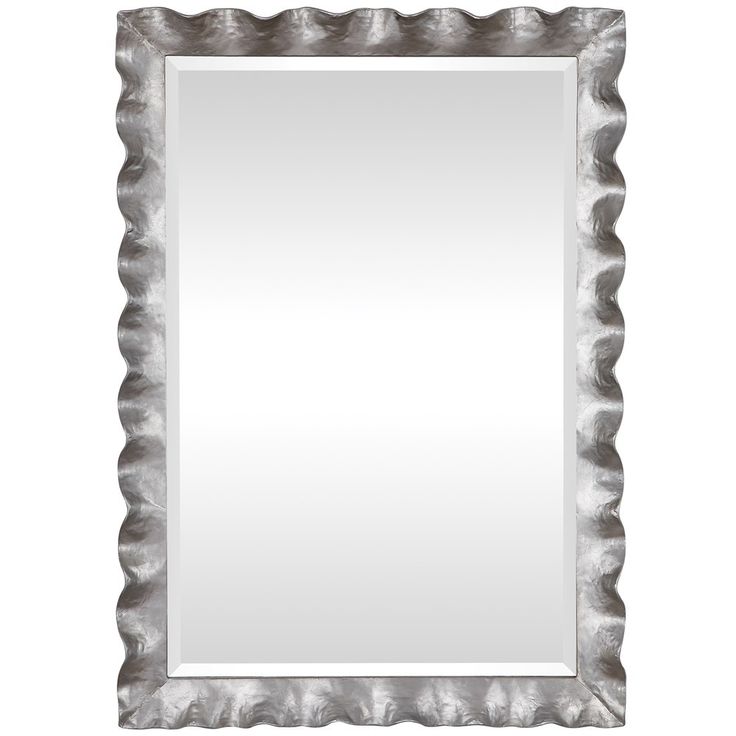 a silver framed mirror on a white wall