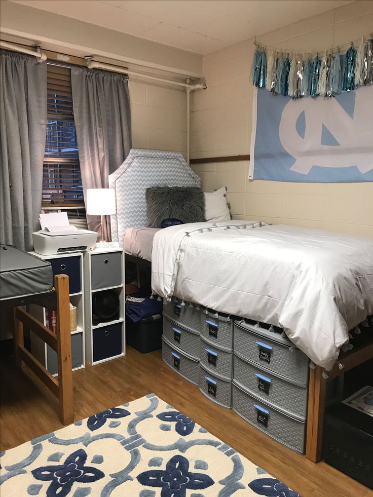 a bedroom with a bed, desk and storage bins