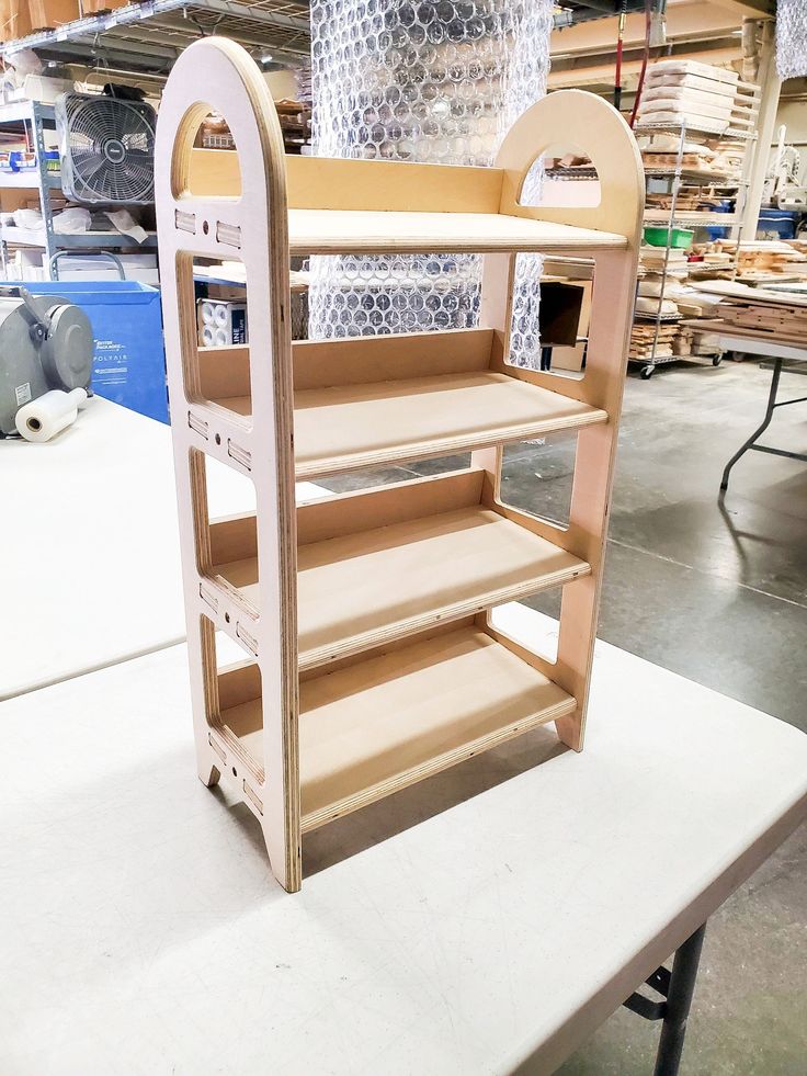 a wooden shelf with shelves on top of it in a warehouse or workshop, ready to be assembled