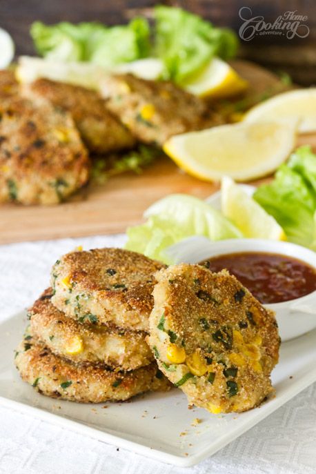 two crab cakes on a plate with sauce and lettuce