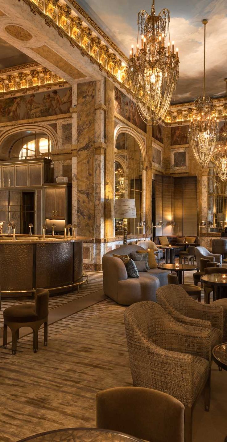 a fancy hotel lobby with chandeliers and seating