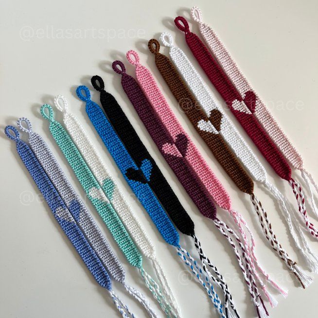 six cross stitch bracelets with hearts and bows on each one side, all in different colors