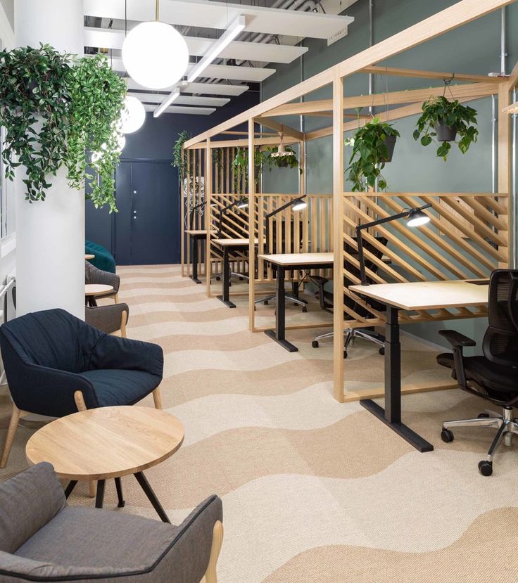 an office with chairs, desks and plants on the wall in it's center