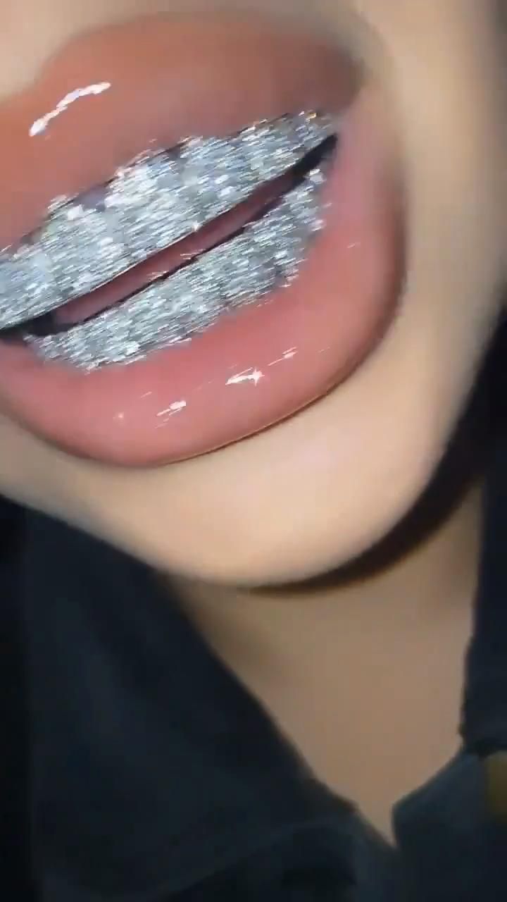 a woman's lips with silver glitter on them and her tongue sticking out to the side