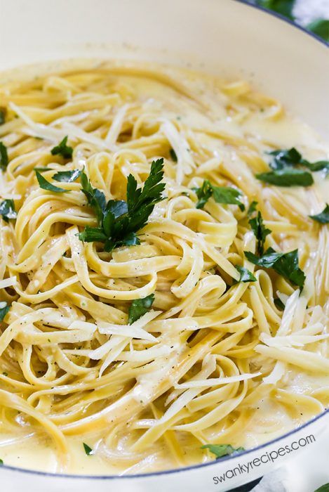 pasta with parmesan cheese and herbs in a white bowl